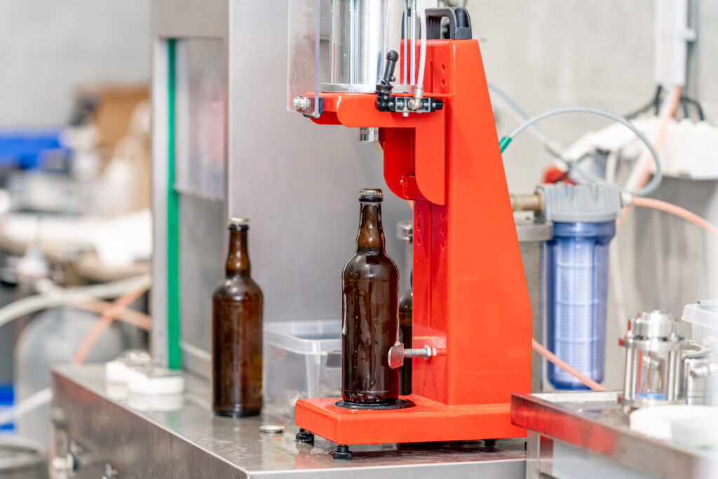 capping beer bottles in a brewery.